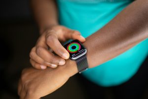 Close-up of a person checking their fitness progress rings on a smartwatch.