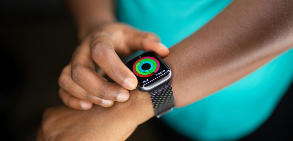 Close-up of a person checking their fitness progress rings on a smartwatch.