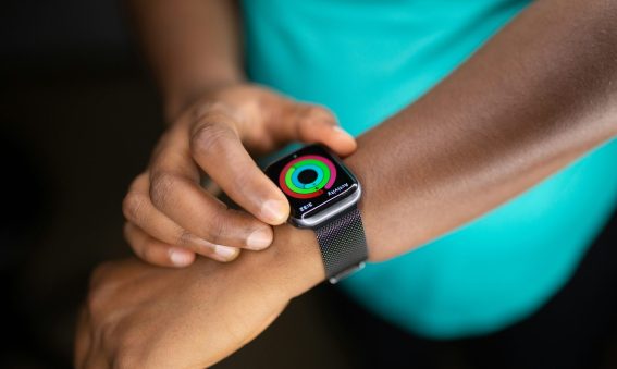 Close-up of a person checking their fitness progress rings on a smartwatch.